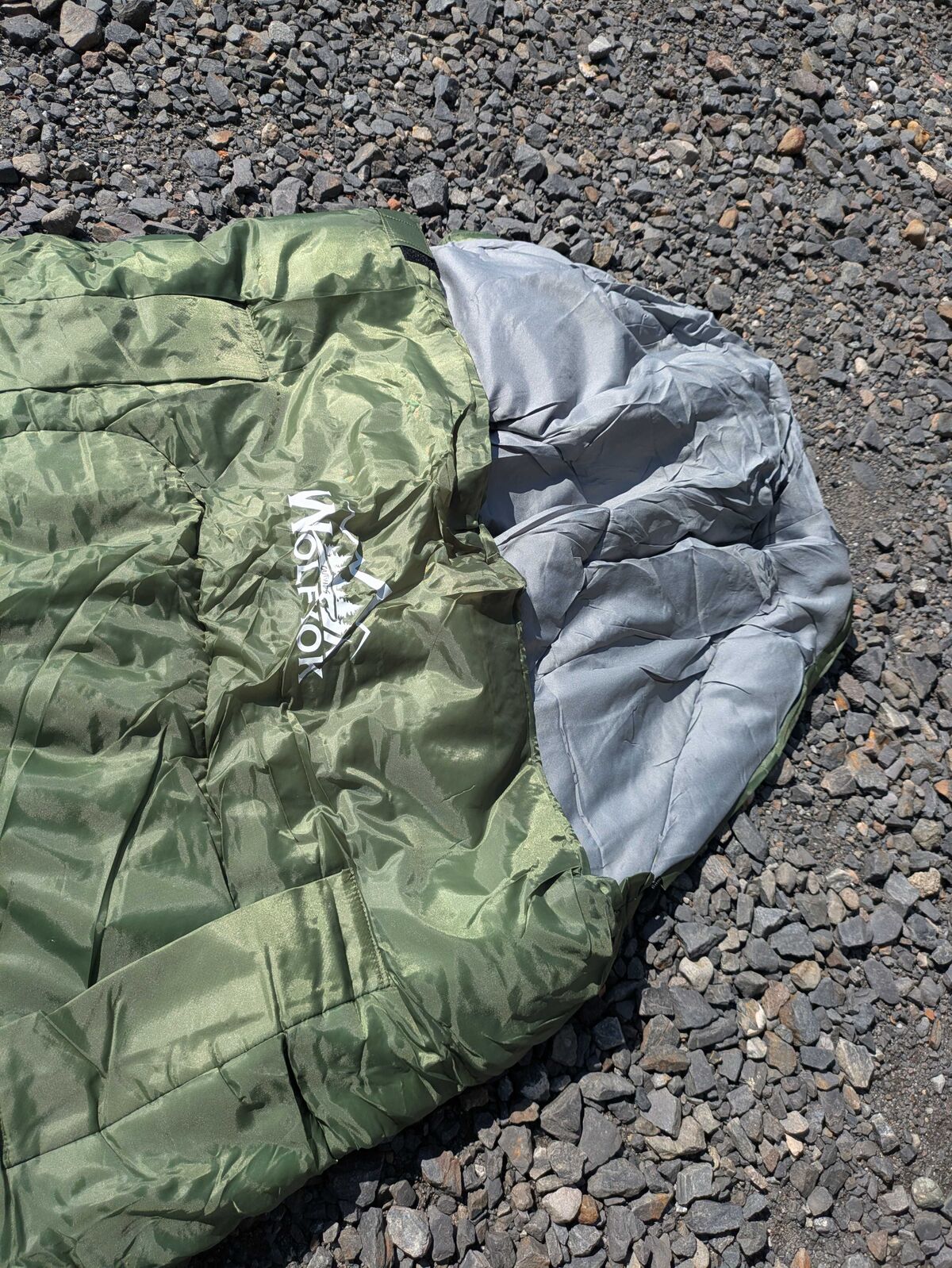 Wolfyok outdoors寝袋を砂利の上に広げたところ
